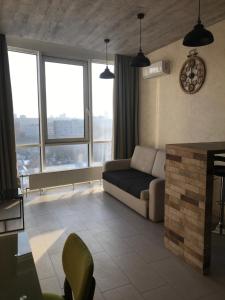 a living room with a couch and some windows at Apart Plaza 24 in Kyiv