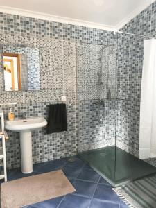 een badkamer met een glazen douche en een wastafel bij LAVA Açores Coliving & Coworking in Ribeira Grande