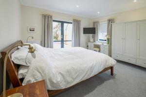 um quarto com uma cama branca e uma janela em Church Farmhouse - Castle View (4 bedroom) & Church View (2 bedroom) em Castletown