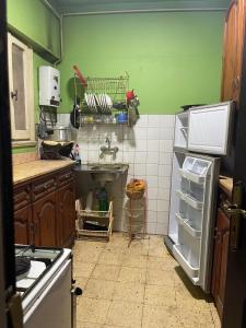 - une cuisine avec des murs verts et un réfrigérateur ouvert dans l'établissement شقه مفروشه سوبر لوكس بميامى الاسكندريه, à Alexandrie