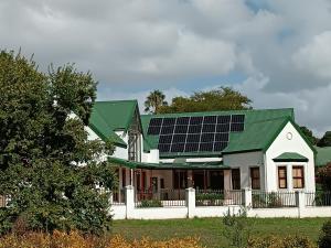 a house with solar panels on the roof at Luxury Secure Flat Apartment in Plattekloof