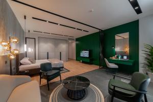 a bedroom with green walls and a bed and a table at Dostyk Business Hotel in Aktau