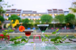 Dwa kieliszki martini na stole. w obiekcie Hoi An Riverland Villa - Hoi An Center w Hoi An
