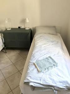ein Schlafzimmer mit einem Bett und einem Nachttisch mit zwei Lampen in der Unterkunft Casa Su Soli Sardu 10 - Mit Blick aufs Meer! in Codaruina