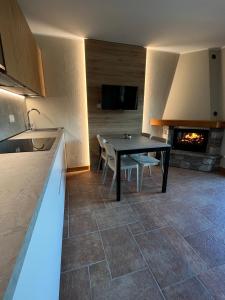 Villa dʼAllegno的住宿－Chalet La Stella Alpina，厨房配有餐桌和壁炉