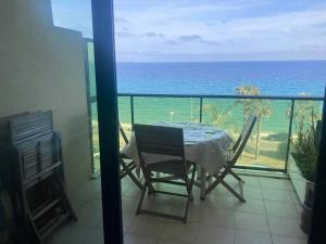 einen Tisch und Stühle auf einem Balkon mit Meerblick in der Unterkunft CANNES Front de mer in Cannes