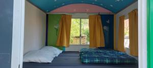 1 dormitorio con 1 cama en una habitación con ventana en Slaaphuisjes op wielen BuitenWedde Westerwolde en Wedde