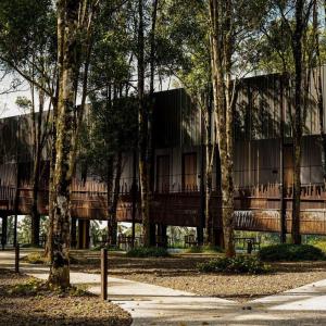 a large building with a balcony in front of trees at Teras Hotel Ijen Banyuwangi in Banyuwangi