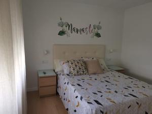 a bedroom with a bed with a sign on the wall at Ideal parejas in Moaña