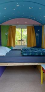 Wedde的住宿－Slaaphuisjes op wielen BuitenWedde Westerwolde，蓝色天花板的客房内的双层床