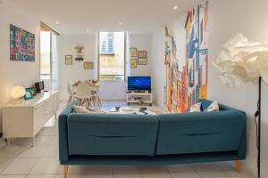uma sala de estar com um sofá azul num quarto em 26 nice em Nice