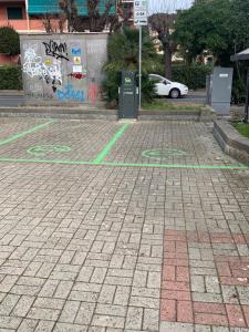 a parking lot with green lines on a brick road at Appartamento Note d’estate in Marina dʼAndora