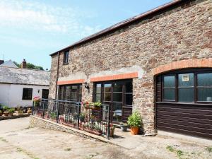 ein Backsteingebäude mit einem Balkon mit Blumen darauf in der Unterkunft The Corn Tallet in Bideford