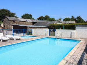 a large swimming pool with two chairs and a building at The Corn Tallet in Bideford