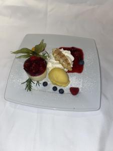 a white plate with food on a white table at Hotel Pfaff in Triberg