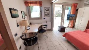 een slaapkamer met een bureau met 2 stoelen en een bed bij Luxury apartment SEA HELM with private swimming pool and BBQ in Lagonissi