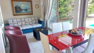 - un salon avec une table et des chaises rouges dans l'établissement Luxury apartment SEA HELM with private swimming pool and BBQ, à Lagonissi