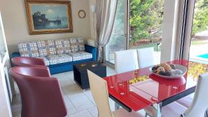 een woonkamer met een rode tafel en stoelen bij Luxury apartment SEA HELM with private swimming pool and BBQ in Lagonissi