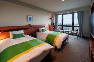 a hotel room with two beds and a large window at Akarinoyado Togetsu in Beppu