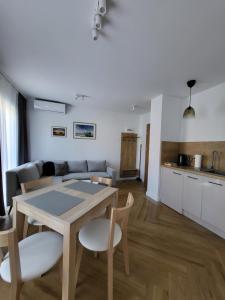 a living room with a table and chairs and a kitchen at Apartamenty Julia APARTAMENTY OZONOWANE in Ustronie Morskie