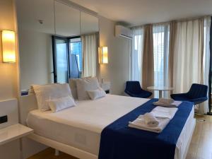 a bedroom with a large bed with towels on it at Orbi City Tower Best Apartment in Batumi in Batumi