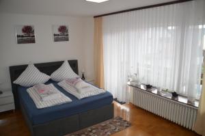 Un dormitorio con una cama azul y una ventana en Fewo Magnolie, en Eschwege