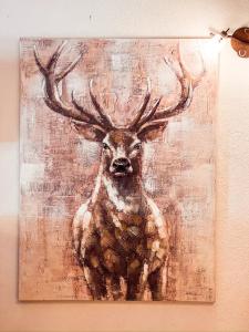 a painting of a deer with antlers on a wall at Green Park Studio Courmayeur in Courmayeur