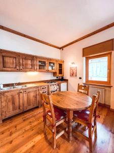 a kitchen with a wooden table and wooden cabinets at Green Park Studio Courmayeur in Courmayeur