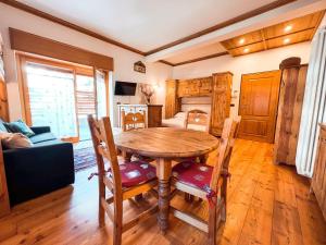 a dining room with a wooden table and chairs at Studio Bijoux Des Alpes Verrand-Courmayeur in Courmayeur