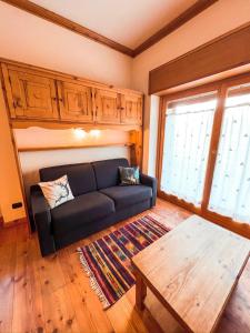 a living room with a couch and a table at Green Park Studio Courmayeur in Courmayeur