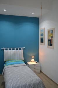 ein Schlafzimmer mit einer Wand mit blauen Akzenten und einem Bett in der Unterkunft Gloria Vatican Bijou in Rom