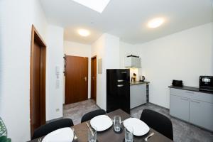 eine Küche und ein Esszimmer mit einem Tisch und Stühlen in der Unterkunft Modernes Apartment in der Innenstadt in Würzburg