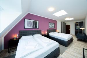 1 Schlafzimmer mit 2 Betten und einer lila Wand in der Unterkunft Modernes Apartment in der Innenstadt in Würzburg