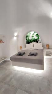 a white bedroom with a bed with two pillows on it at Volcan Secret Cave in Karterados
