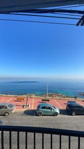 XgħajraにあるSG seaview apartmentの海上近くの駐車場に停車する車の一団