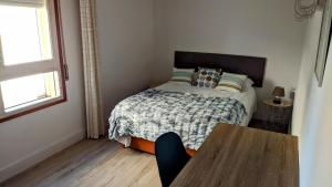 a small bedroom with a bed and a table at Primera línea en Segur de Calafell in Calafell