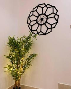 een zwart-witte klok op een muur met een plant bij Ssrhomestay/S2/Corner lot/15pax in Seremban