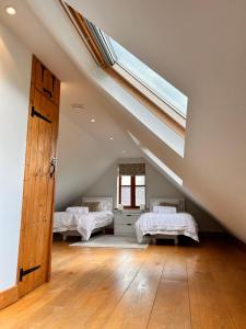 a attic room with three beds and a skylight at The Annexe Headcorn in Headcorn