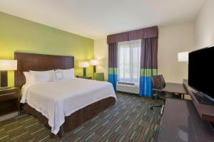 a hotel room with a bed and a flat screen tv at Fairfield Inn & Suites Riverside Corona/Norco in Norco