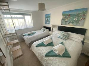 a bedroom with two beds with towels on them at The Garden Flat in Paignton