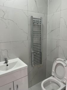 een witte badkamer met een wastafel en een toilet bij Burleigh House - 3 Bed House in Leicester