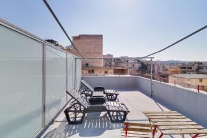 a balcony with chairs and tables on a roof at athensdot in Athens