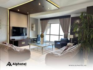 ein Wohnzimmer mit 2 Sofas und einem TV in der Unterkunft Alphatel Beach Hostel JBR in Dubai