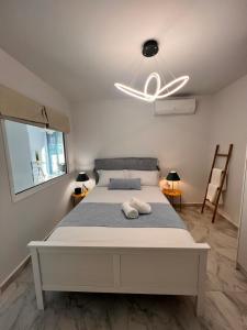 ein weißes Bett in einem Zimmer mit weißer Decke in der Unterkunft Casa de Tres Hermanos in the heart of Athens in Athen