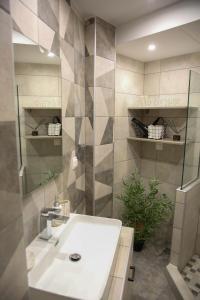 een badkamer met een witte wastafel en een spiegel bij MSK Rotonda Studio 2 in Thessaloniki
