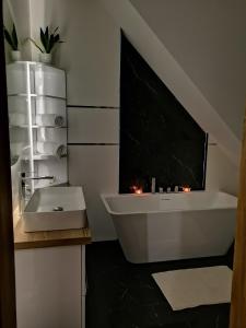 uma casa de banho com uma banheira branca e um lavatório. em Chillout House Serwy em Serwy