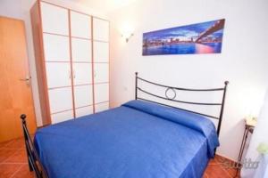 um quarto com uma cama azul num quarto em Villa Tharros em Capoliveri