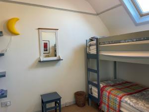 ein Schlafzimmer mit einem Etagenbett und einem Spiegel in der Unterkunft Mai's Cottage Suite - Charming Holiday Rental in Kilmallock