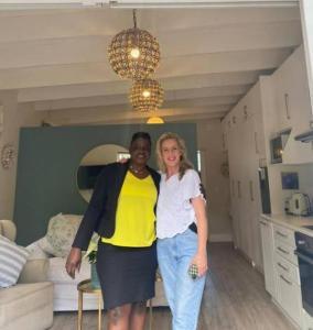 Dos mujeres están de pie en una sala de estar en Gorgeous, private cottage in prestigious Newlands., en Ciudad del Cabo