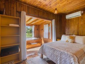 a bedroom with a bed and a large window at Pousada Canyons do Sul in Praia Grande